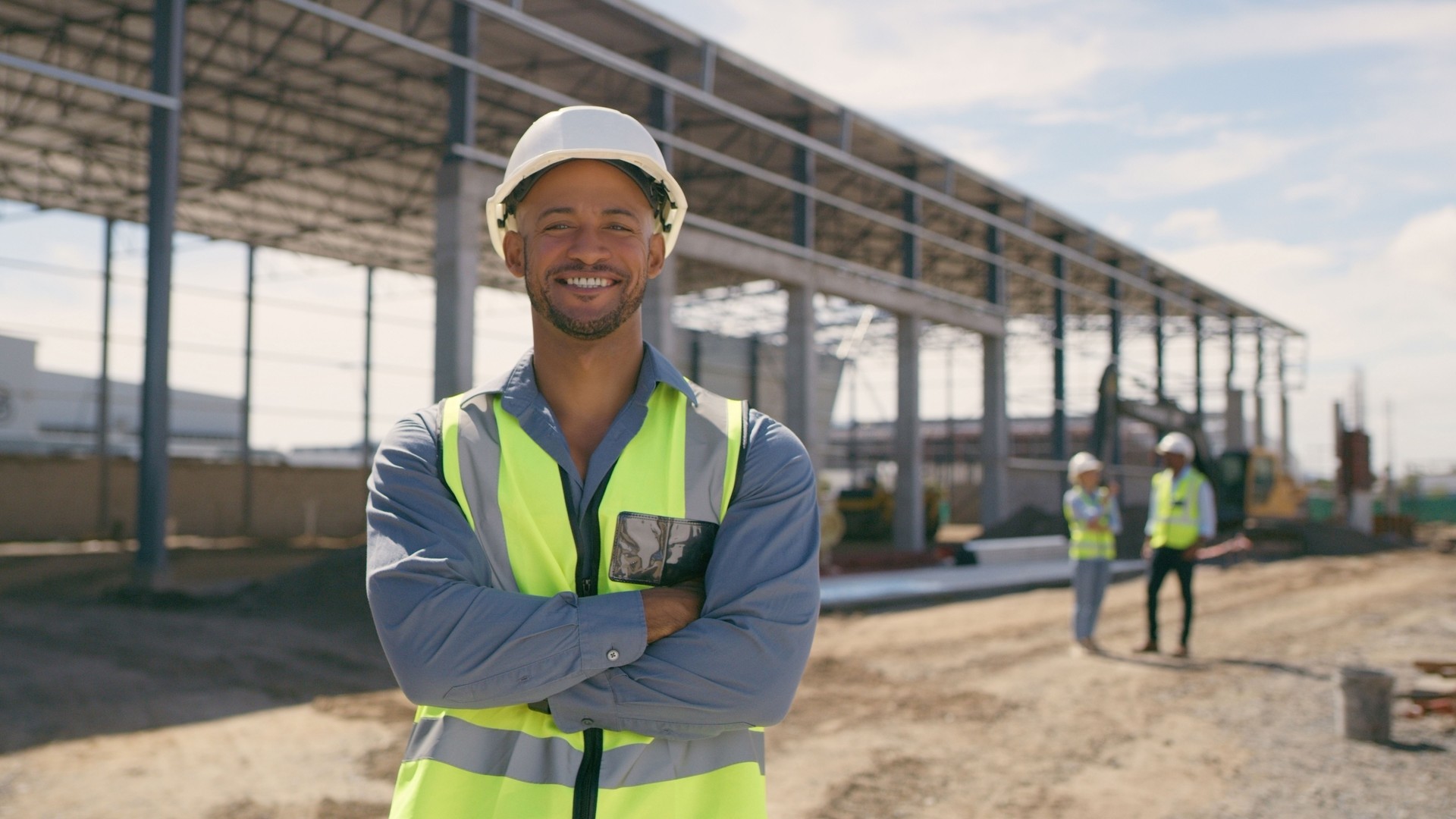 Happy man, construction and face with arms crossed for engineering, project management and labor. Portrait, smile and male builder at building site for property development or infrastructure